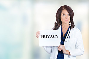 Female Medical Professional holding a piece of paper with the word &quot;PRIVACY&quot; printed on it